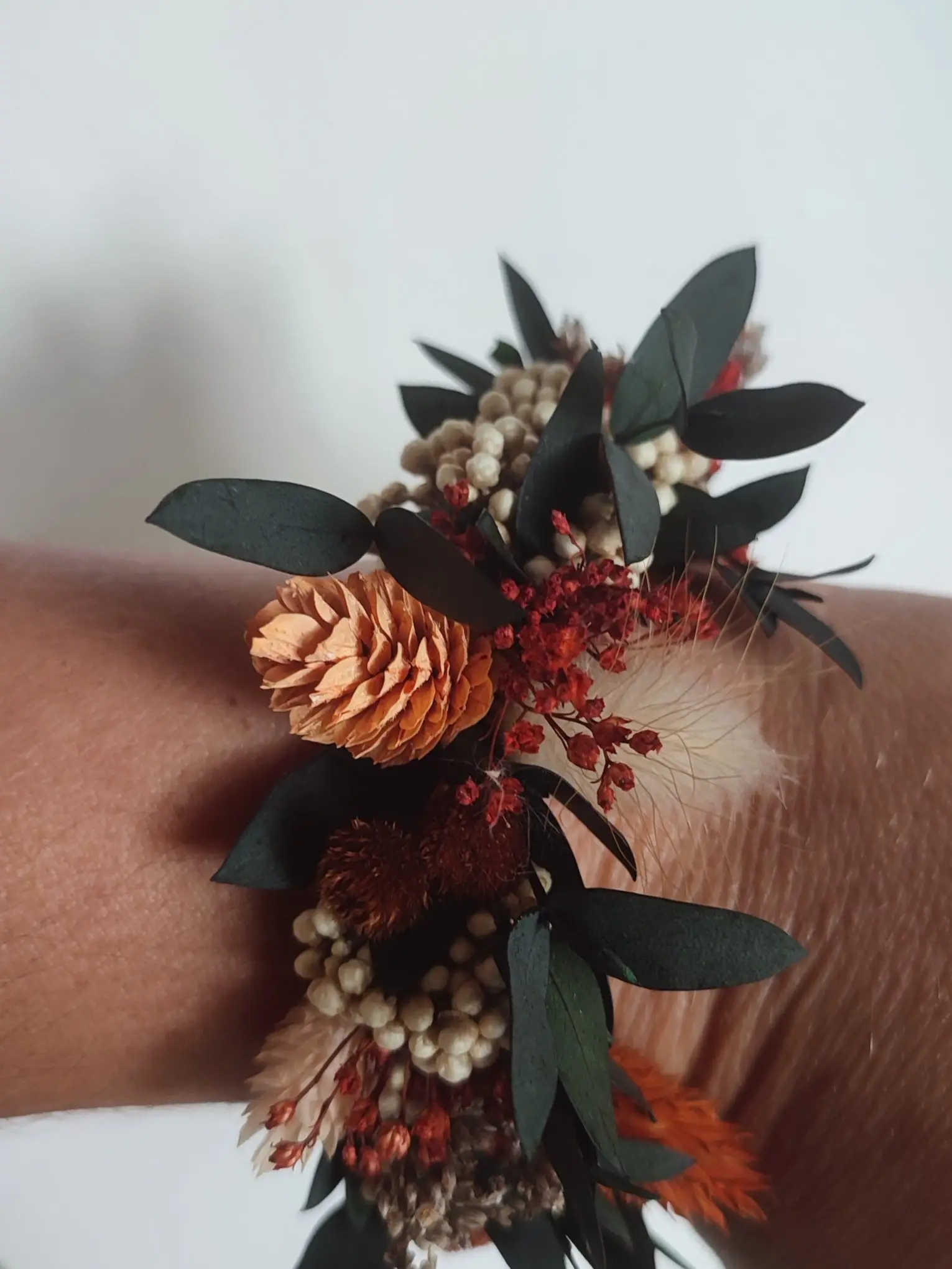 Bracelet de fleurs séchées aux tons rouille, crème et eucalyptus.