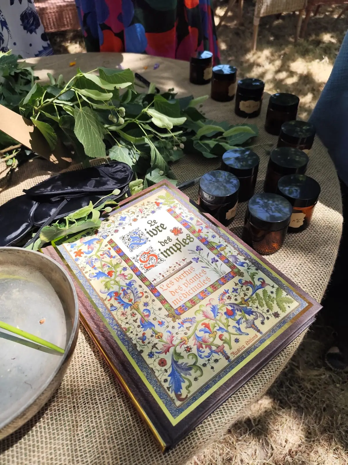 Un livre des simples enluminé, des pots d’herbes et des feuilles fraîches à sentir.